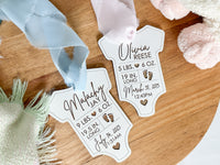 white baby bodysuit ornament with engrave birth stats tied with baby pink and baby blue chiffon ribbon